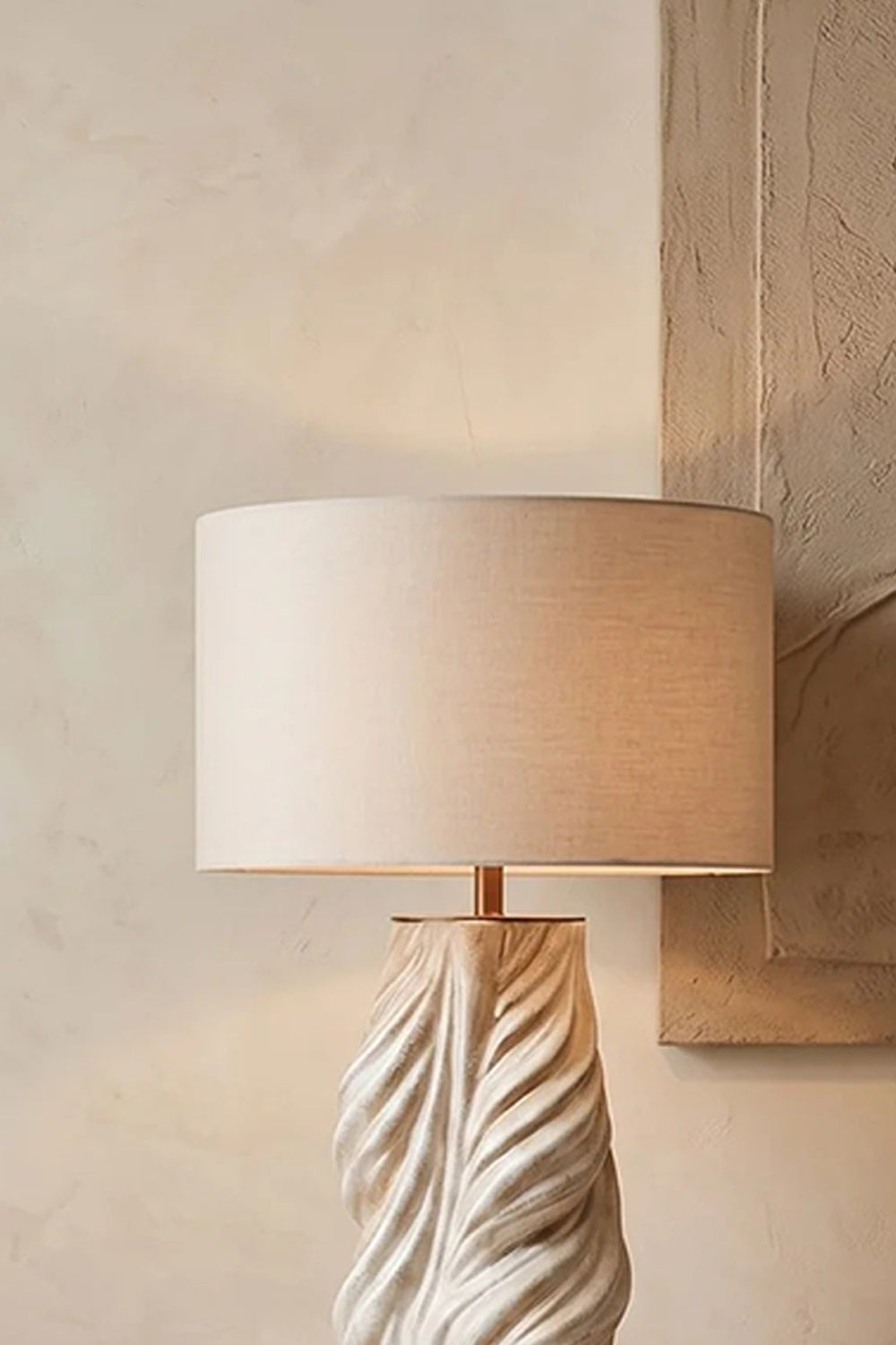 Adara Sculptural Ceramic Table Lamp | Ceramic, Fabric | Detailed close-up focus highlighting the texture of the off-white fabric drum shade and the upper twisted ceramic ridge detail | Detail shot | Samu Lamp
