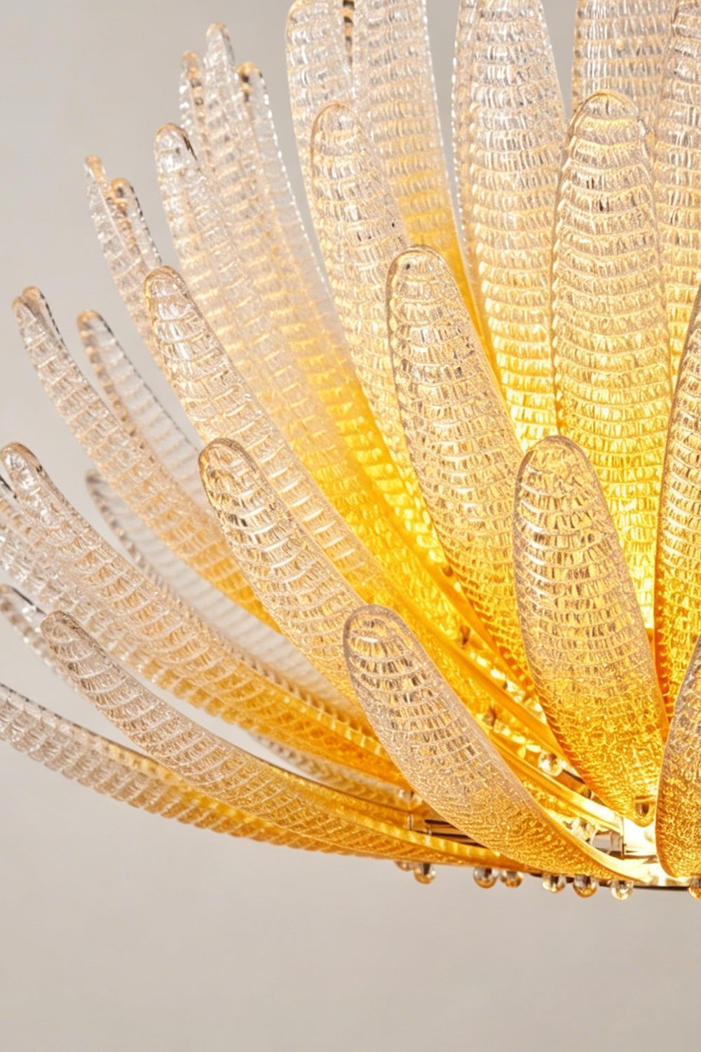 Helios Agave Glass Starburst Chandelier | Glass, Metal | Close-up focus on the spiky, upward-reaching textured glass petals with a golden glow | Detail shot | Samu Lamp Helios Agave