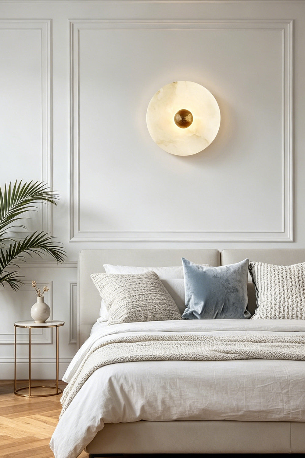 Alabaster disc wall sconce for bedroom | Brass | Alabaster | Centered above a bed with white and blue linens | Samu Lamp
