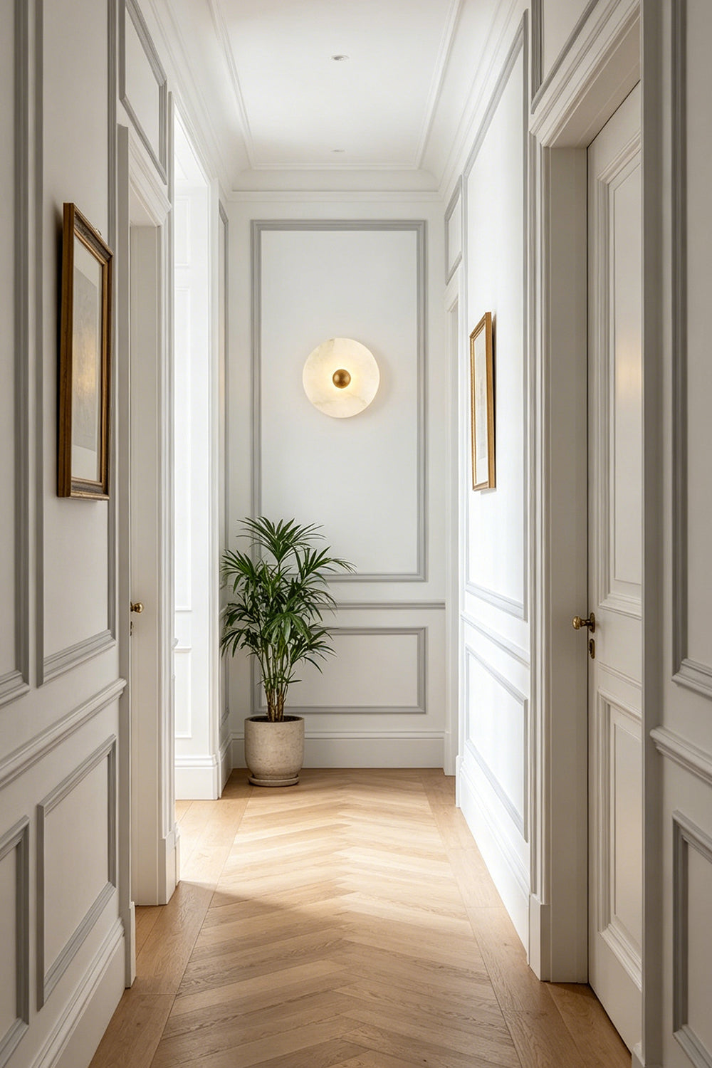 Contemporary alabaster wall lamp | Brass | Alabaster | Installed in a classic hallway with wooden herringbone floors | Samu Lamp