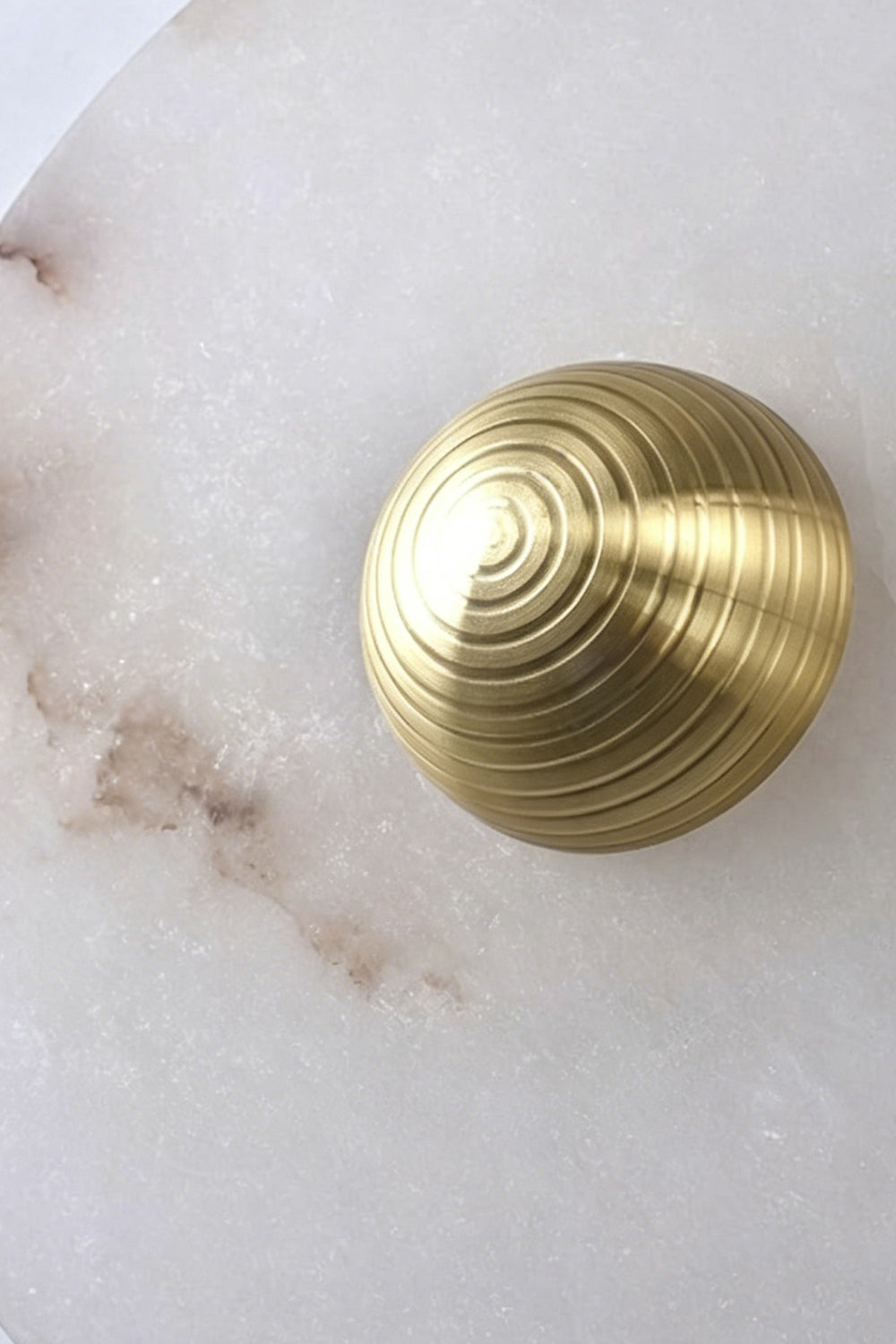 Close-up of ribbed brass center piece on alabaster lamp | Brass | Alabaster | Detail shot showing concentric gold-finish texture | Samu Lamp