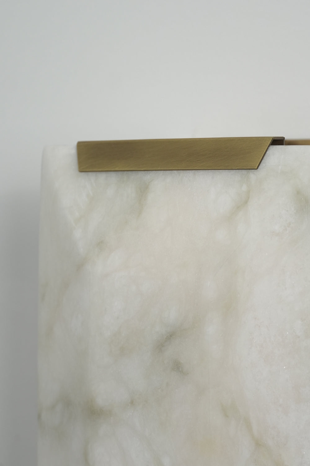 Brass cap detail of alabaster wall lamp | Brass, Alabaster | Close-up showing the metallic edge and stone texture | Samu Lamp