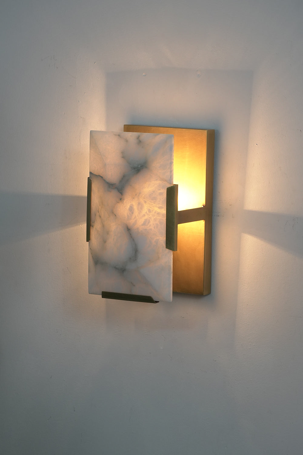 Lit square alabaster wall lamp | Brass, Alabaster | Side perspective showing warm illumination | Samu Lamp
