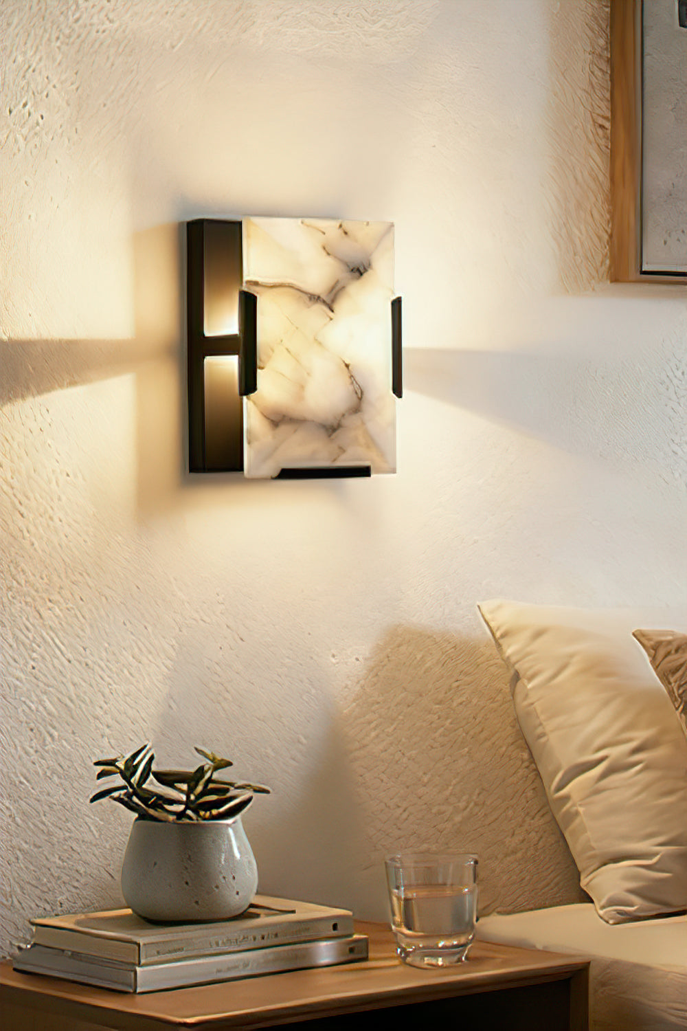 Square alabaster wall sconce with brass bracket | Brass, Alabaster | Installed above a side table in a lounge area | Samu Lamp