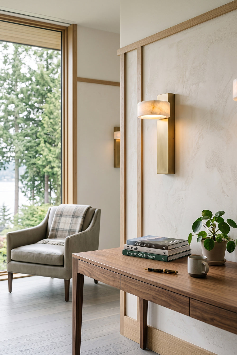 Alaric Alabaster Bar Wall Sconce | Natural Alabaster and Brass | Adding an elegant warm glow to a light minimalist sitting area next to a desk and grey armchair | Samu Lamp