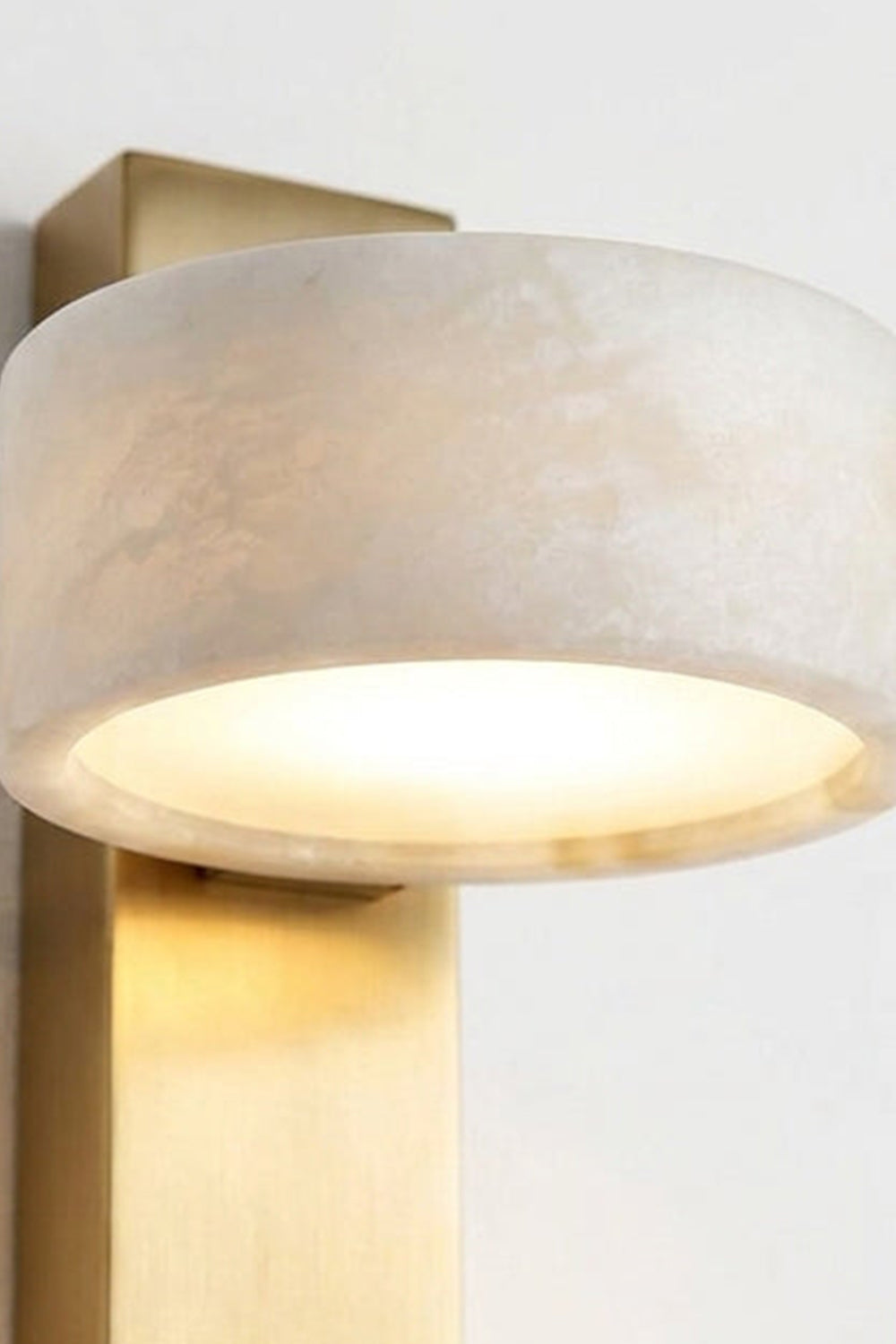Alaric Alabaster Bar Wall Sconce | Natural Alabaster and Brass | Close-up front view of the glowing translucent cylindrical stone shade highlighting its organic veining | Samu Lamp