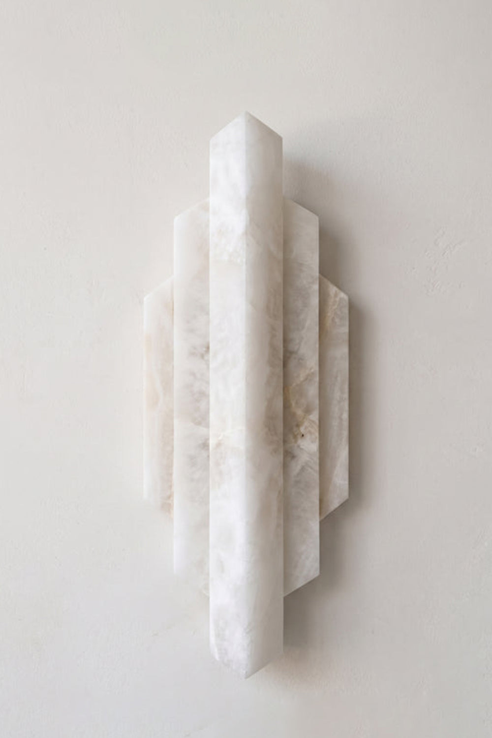 Alaric Tiered Alabaster Wall Sconce | Natural Alabaster and Metal | Front studio view of the unlit white stone fixture showcasing its natural marbled texture on a light background | Samu Lamp