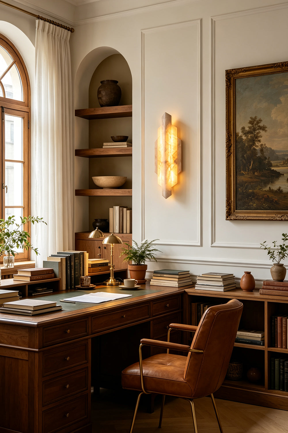 Alaric Tiered Alabaster Wall Sconce | Natural Alabaster and Metal | Illuminating a traditional home office workspace next to a dark wood desk and built-in bookshelves | Samu Lamp