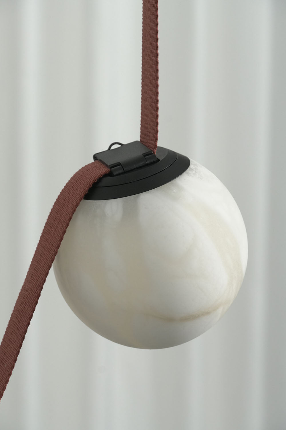 Albiane Draped Chandelier | Alabaster and Woven Strap | Close-up of unlit white alabaster globe and red strap | Samu Lamp