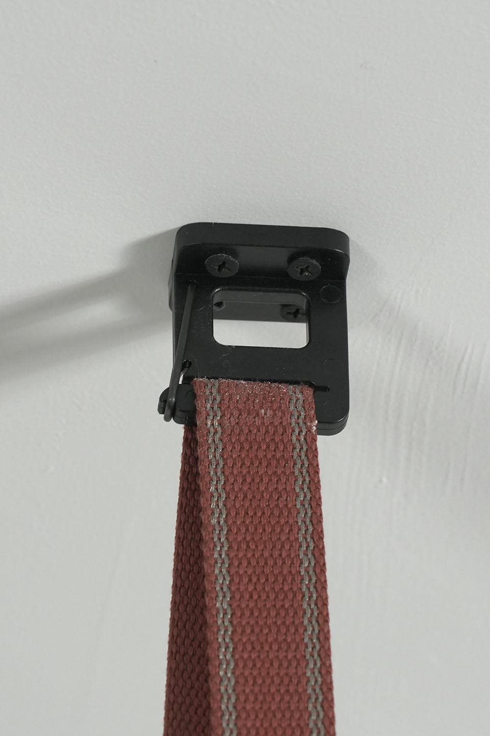 Albiane Draped Chandelier | Woven Strap and Metal | Close-up of black ceiling anchor hook holding red strap | Samu Lamp