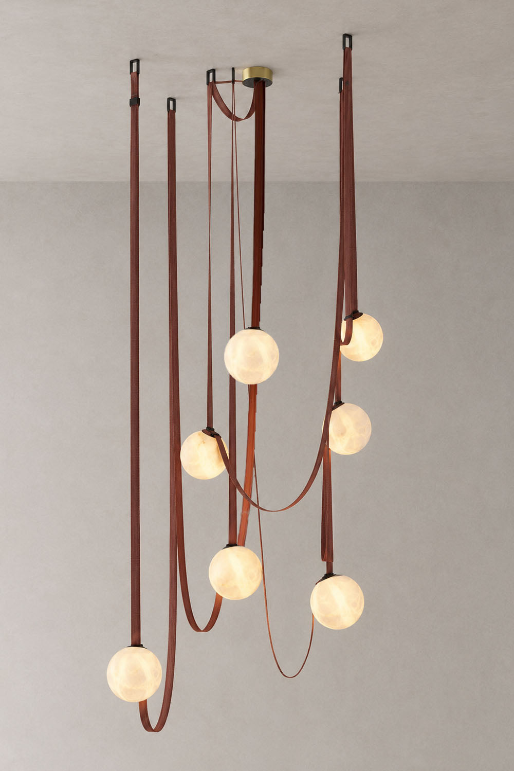 Albiane Draped Chandelier | Alabaster and Woven Rope | Cascading vertical drops with lit globes on white wall | Samu Lamp