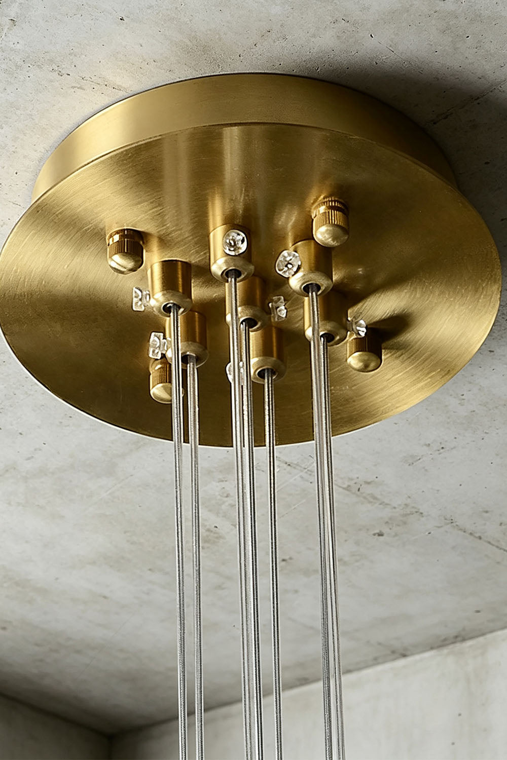 Amandine Alabaster Globe Cluster Pendant Light ceiling fixture with a sleek brass finish and hanging glass rods.