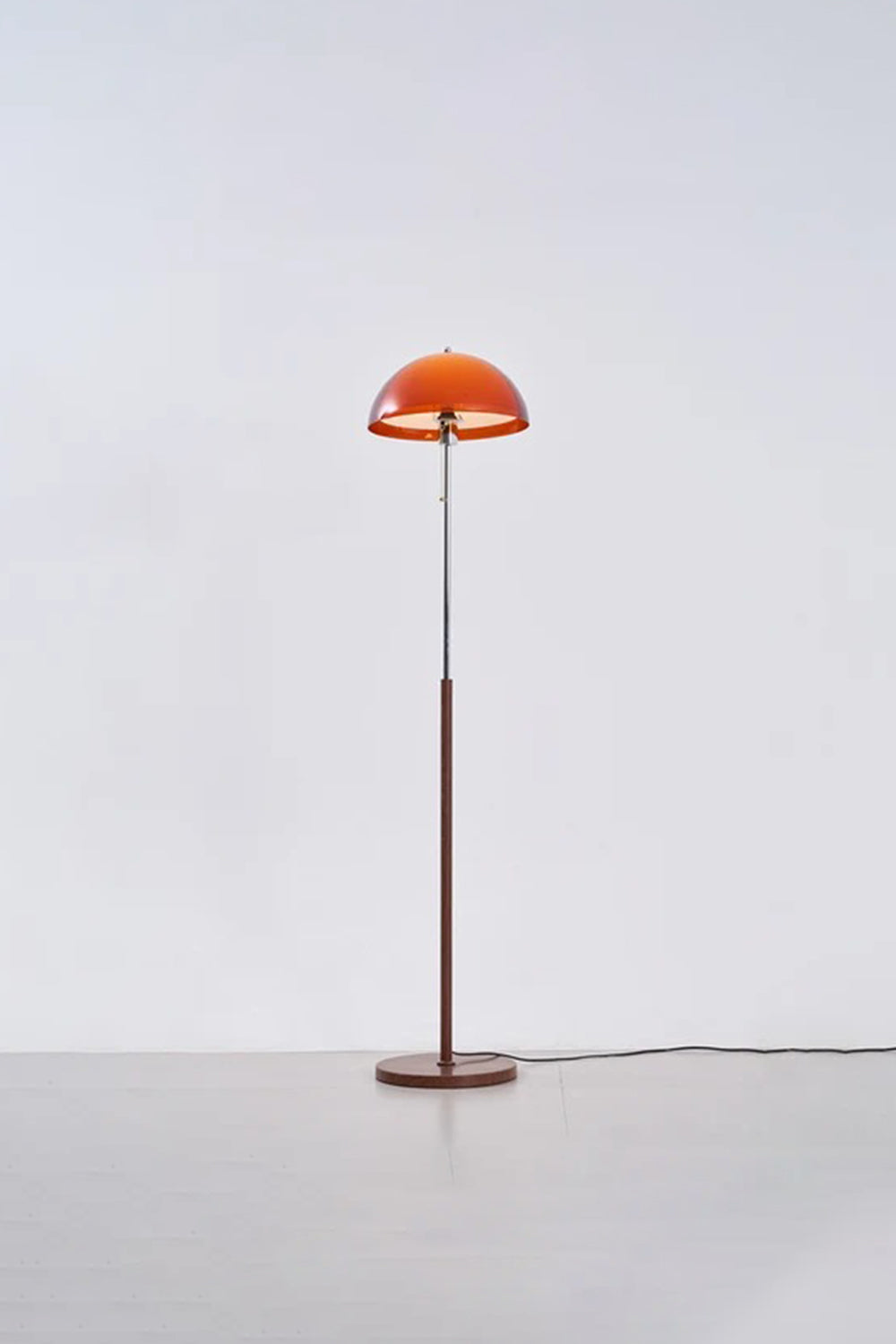 Ambrose Amber Dome Floor Lamp | Amber Glass, Metal and Wood | Full standing view glowing in a studio setting with soft backdrop | Samu Lamp