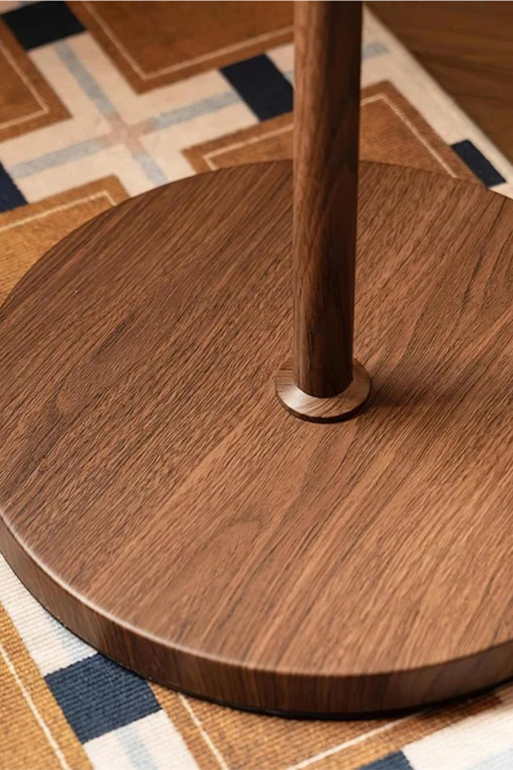 Ambrose Amber Dome Floor Lamp | Amber Glass, Metal and Wood | Detail shot of the smooth circular wood base on a patterned rug | Samu Lamp