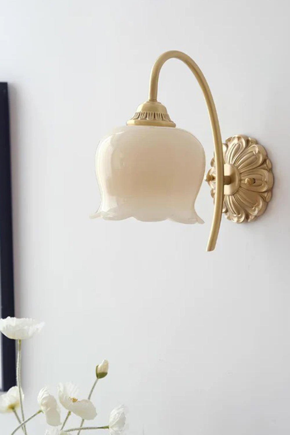 Amelie Vintage Tulip Wall Lamp with frosted glass shade and antique brass backplate illuminating a floral-inspired interior.