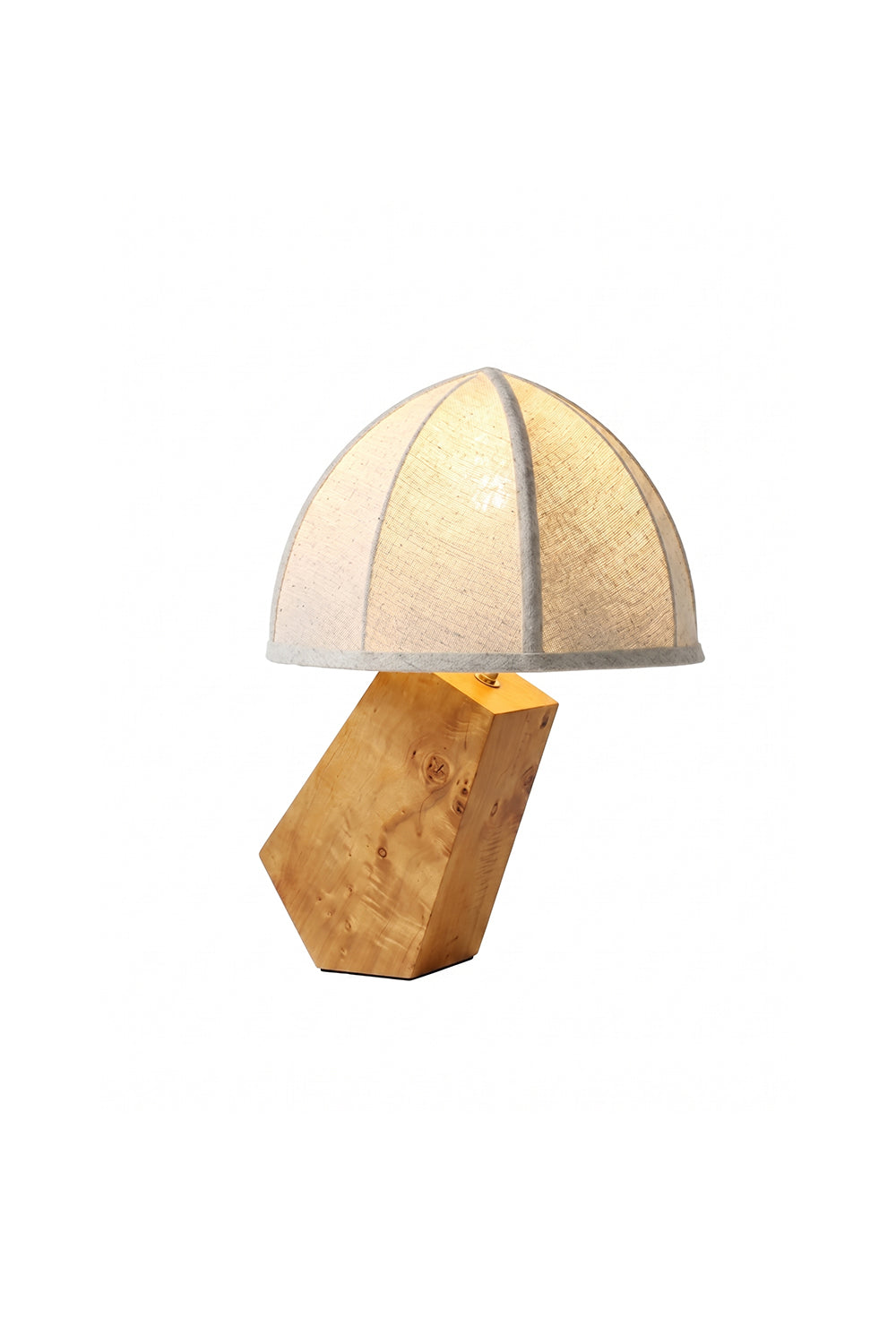 Angolo Canted Faceted Wood Table Lamp | Wood, Fabric, Metal | Table lamp featuring a paneled fabric dome shade and a sculptural faceted wood block base | Isolated lit product shot on white background | Samu Lamp