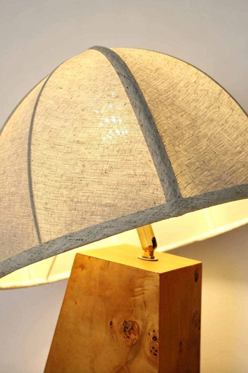 Angolo Canted Faceted Wood Table Lamp | Wood, Fabric, Metal | Close-up view showing the junction between the fabric dome shade and the faceted wood base | Detail shot | Samu Lamp
