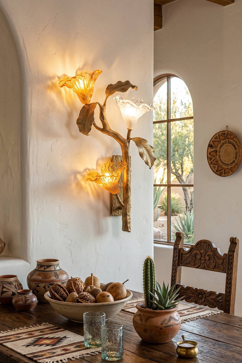 Arboreal Bloom Brass Wall Lamp | Brass, Glass | The Arboreal Bloom brass wall lamp mounted next to a bed with patterned textiles, a carved wooden nightstand, and desert art in a rustic bedroom | Lifestyle in-situ shot | Samu LampArboreal Bloom