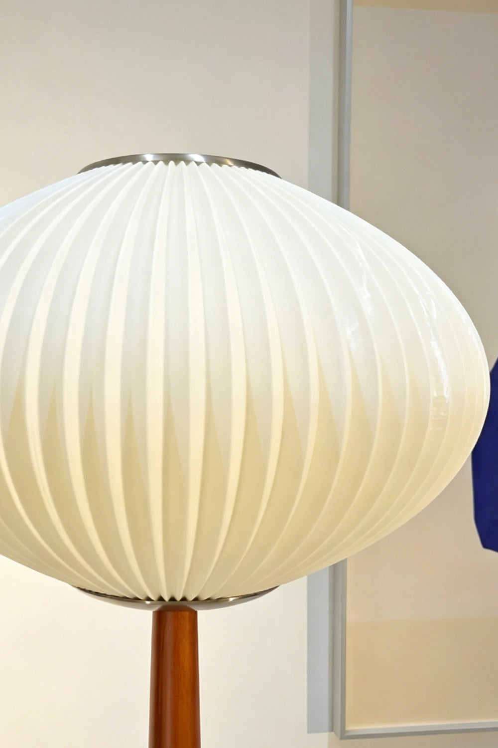 Arden Walnut Floor Lamp | Wood, Metal, Fabric | Close-up focus on the illuminated white ribbed pleated saucer lampshade showcasing the soft light diffusion and texture | Detail shot | Samu Lamp