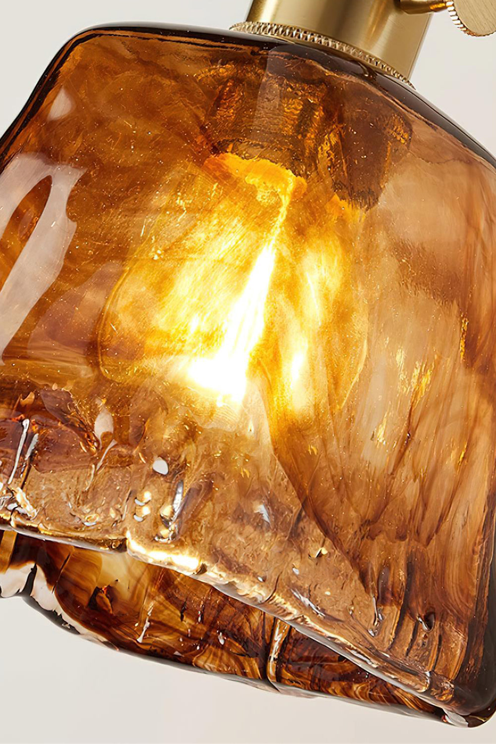 Arlo Amber Ripple Wall Lamp | Glass, Metal, Wood | Detailed close-up showing the organic ripple texture and translucent honey amber glow of the illuminated glass shade | Detail shot | Samu Lamp