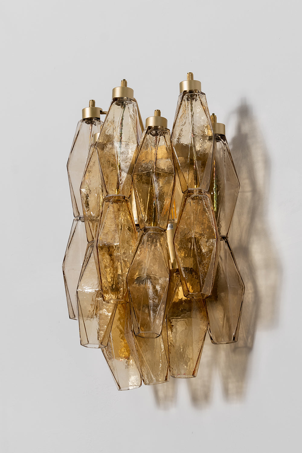 Unlit amber polyhedral glass sconce with metal hooks | Metal, Glass | Side perspective product shot | Samu Lamp