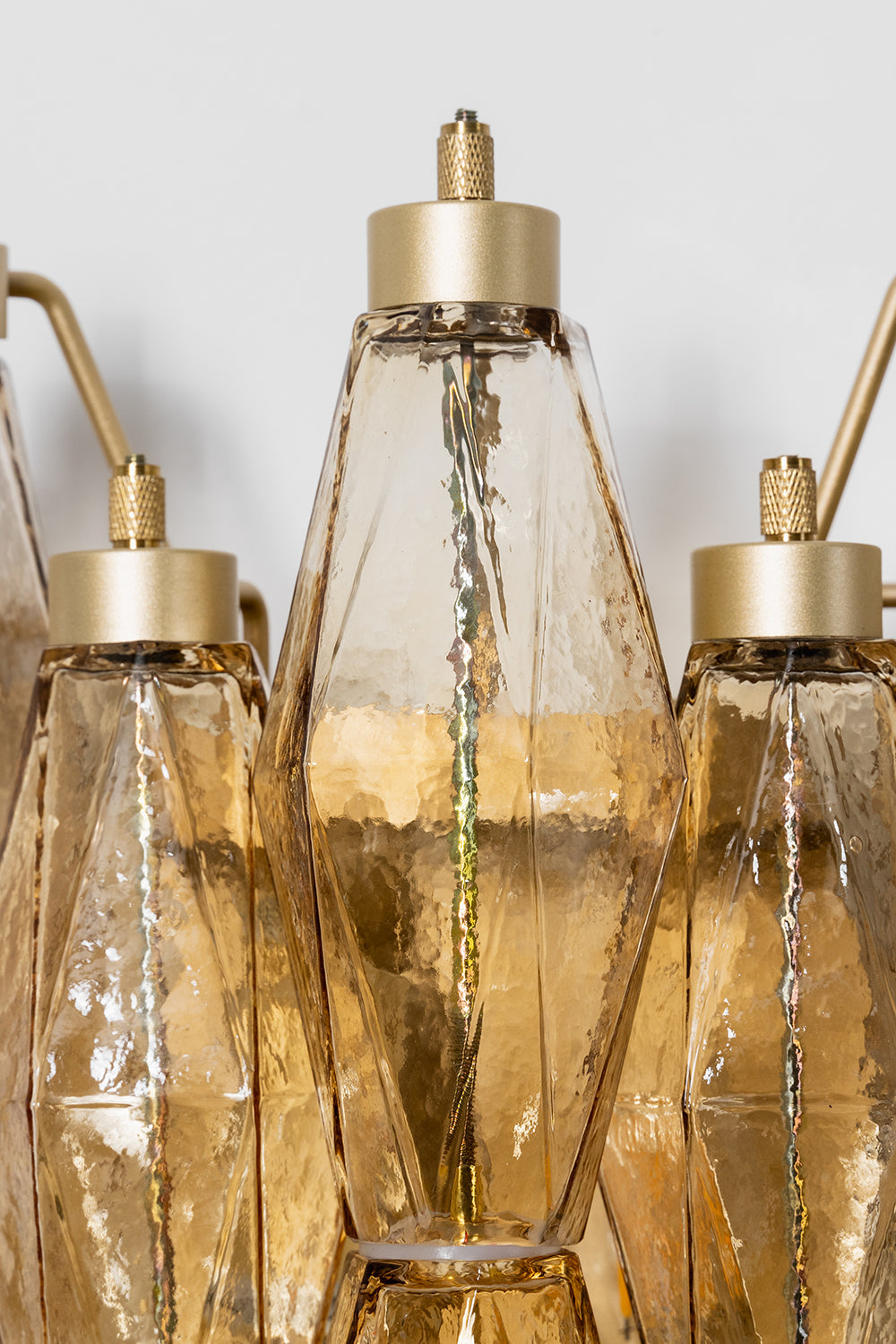 Close-up of metal hardware and amber glass prisms | Metal, Glass | Top detail showing the brass-finish hangers | Samu Lamp