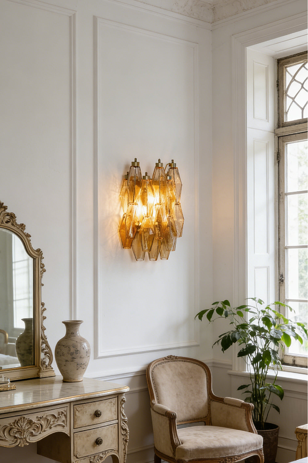 Amber Art Poliedri glass wall sconce providing warm glow | Metal, Glass | Traditional room setting with vanity mirror and chair | Samu Lamp