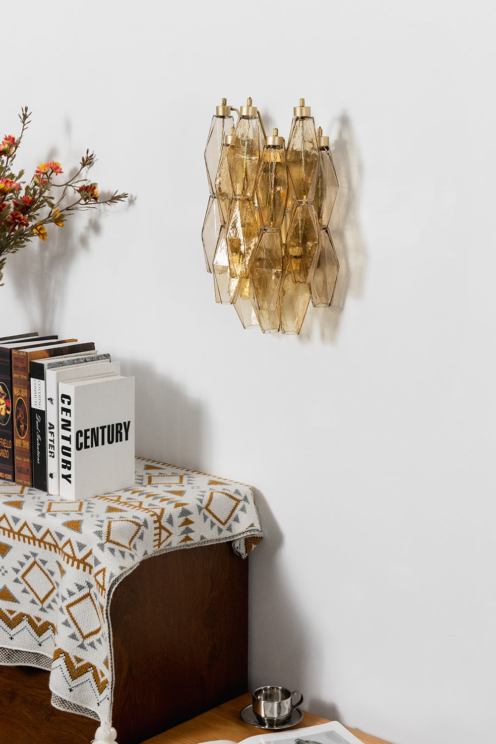 Unlit amber polyhedral glass wall lamp | Metal, Glass | Side perspective view above a decorative console | Samu Lamp