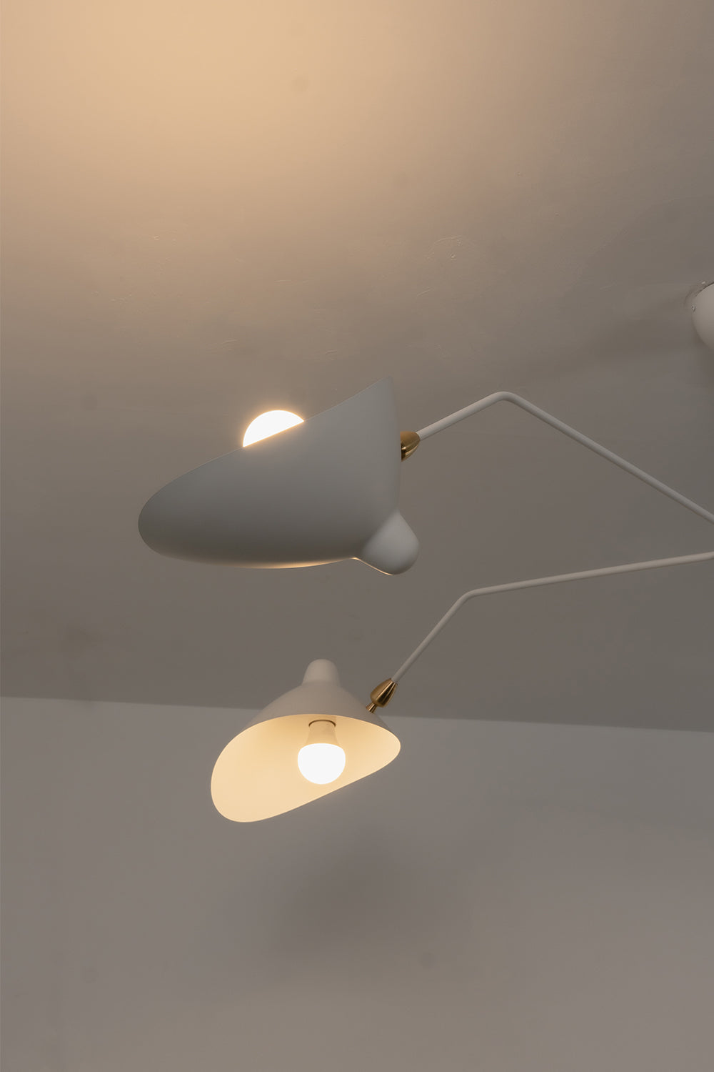 Close-up of lit white articulated lamp shades | Metal | Detail shot showing light diffusion and pivot joints | Samu Lamp