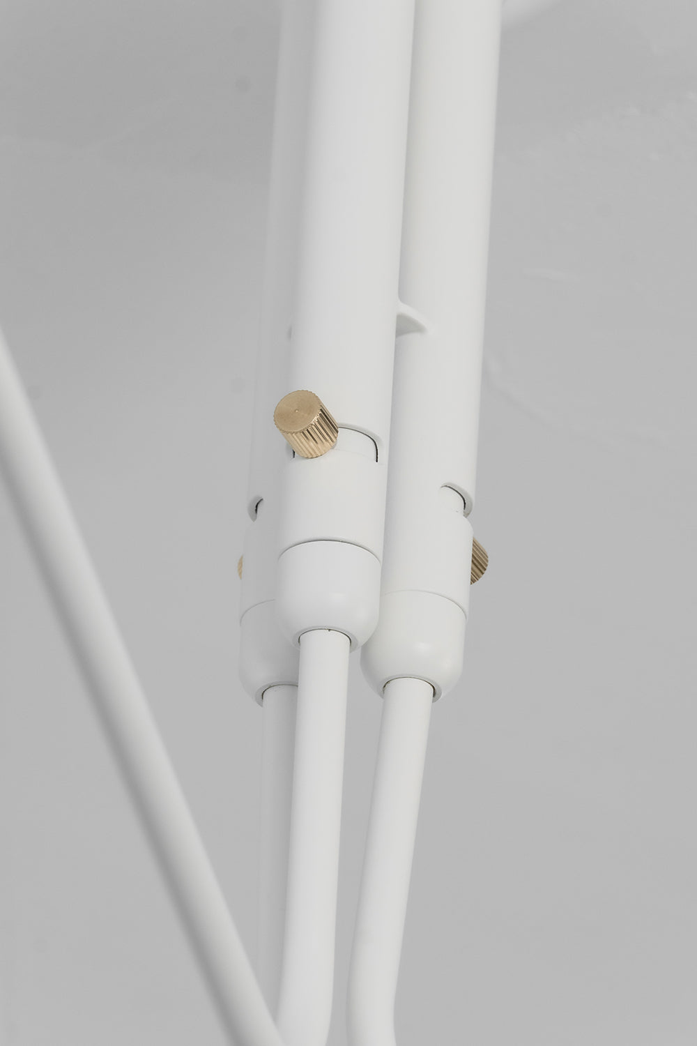 Brass pivot joint detail on white spider light | Metal | Functional detail shot of the articulated arm mechanism | Samu Lamp