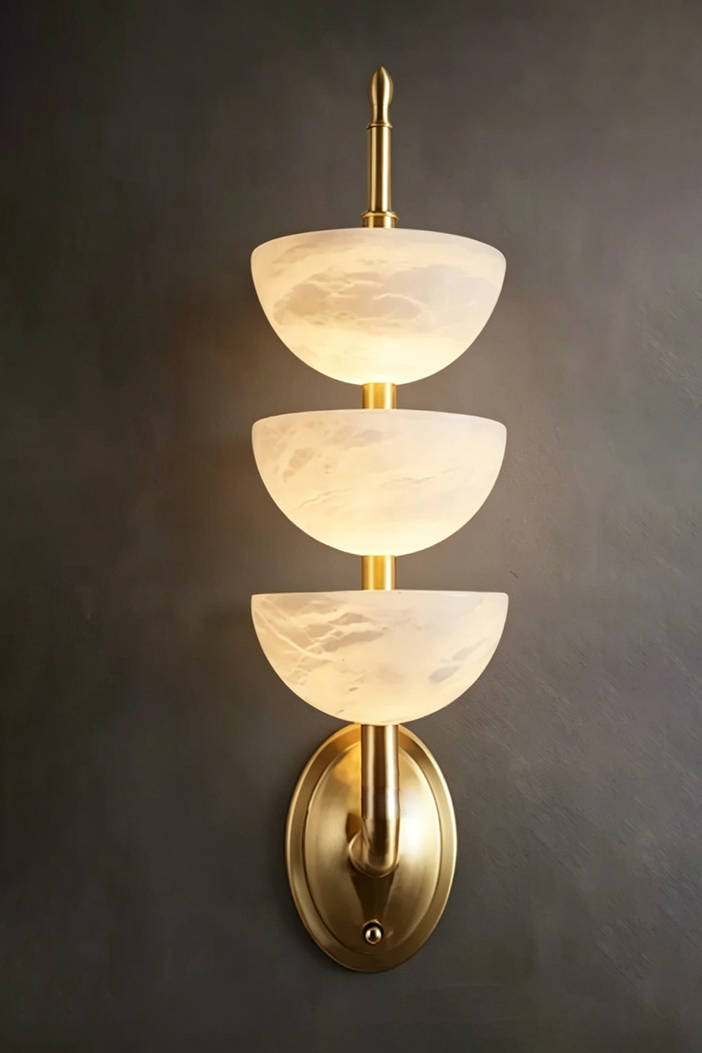 Ascendant Wall Lamp on dark wall | Alabaster, Brass | High contrast lit view against charcoal background | Samu Lamp