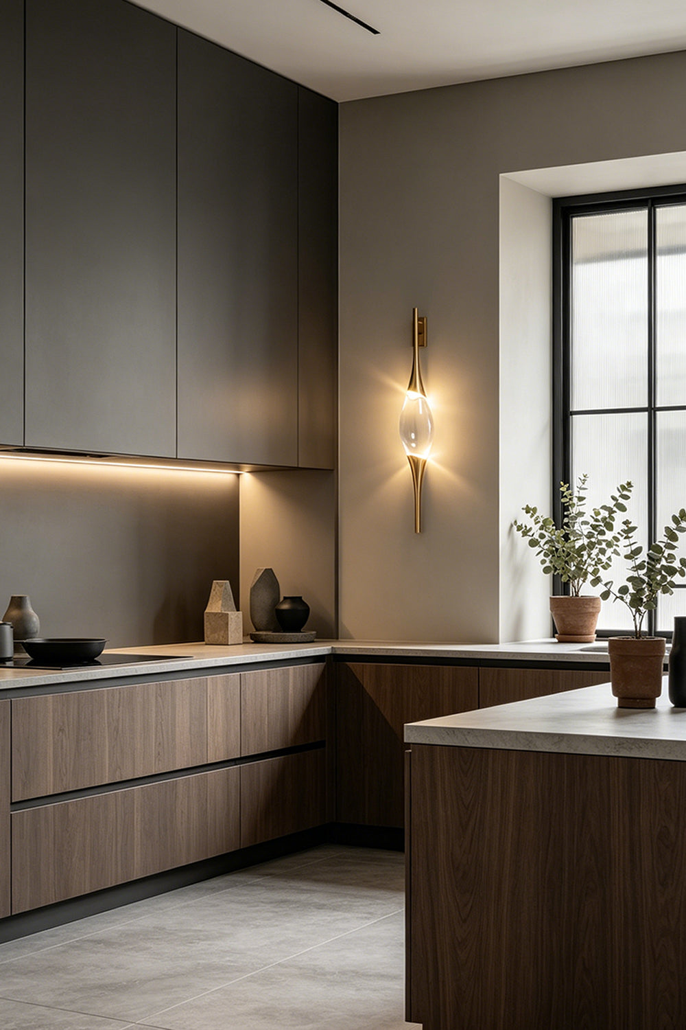 Astraea Crystal Linear Wall Sconce | Crystal, Brass | Installed as a luxury wall accent in a modern kitchen with dark matte cabinetry and a grey backsplash | Samu Lamp