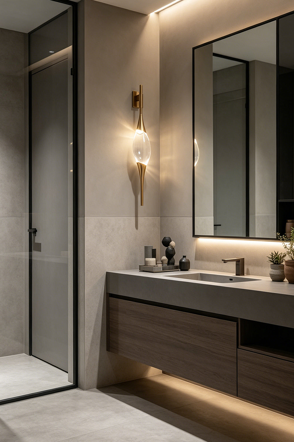 Astraea Crystal Linear Wall Sconce | Crystal, Brass | Mounted beside a mirror in a sleek modern minimalist bathroom vanity area, casting a warm elegant glow | Samu Lamp