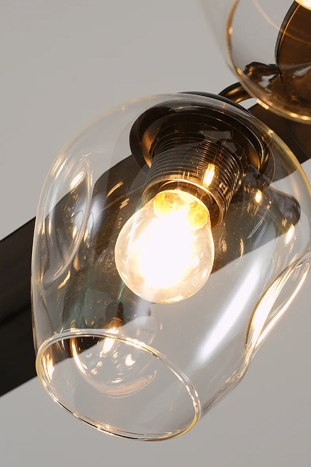 Astraea Modern Glass Globe Ceiling Fan Light | Glass, Metal, Wood | Side angled close-up view highlighting the organic curves of the transparent glass globe shades and black hardware fittings | Detail shot | Samu Lamp