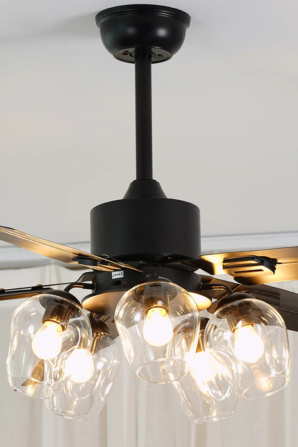 Astraea Modern Glass Globe Ceiling Fan Light | Glass, Metal, Wood | Close-up front view of the fan light cluster illuminated against a white ceiling, highlighting the matte black downrod assembly | Detail shot | Samu Lamp