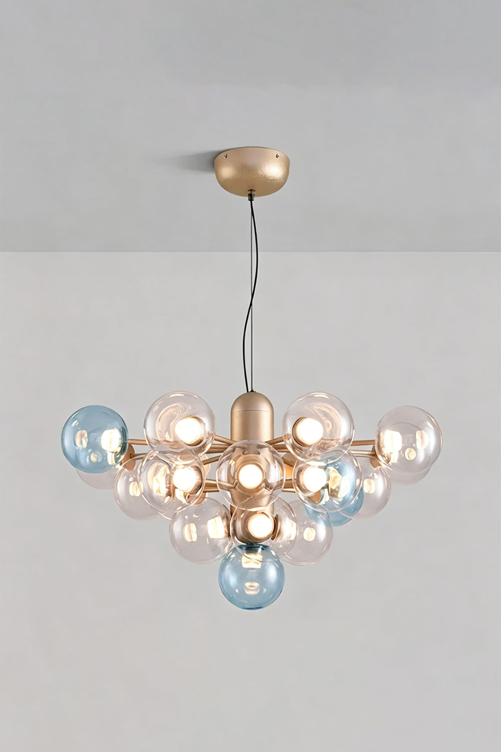 Astraea Prismatic Globe Chandelier | Glass, Metal | Studio view of the ocean blue glass bubble variant fully illuminated against a plain grey backdrop | Samu Lamp