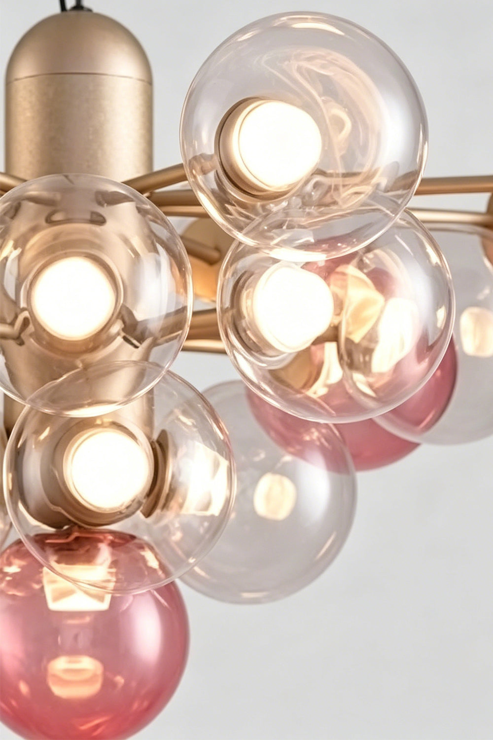 Astraea Prismatic Globe Chandelier | Glass, Metal | Up-close shot highlighting the satin gold metal central housing tube and clustered glass bubbles refracting warm light | Detail shot | Samu Lamp