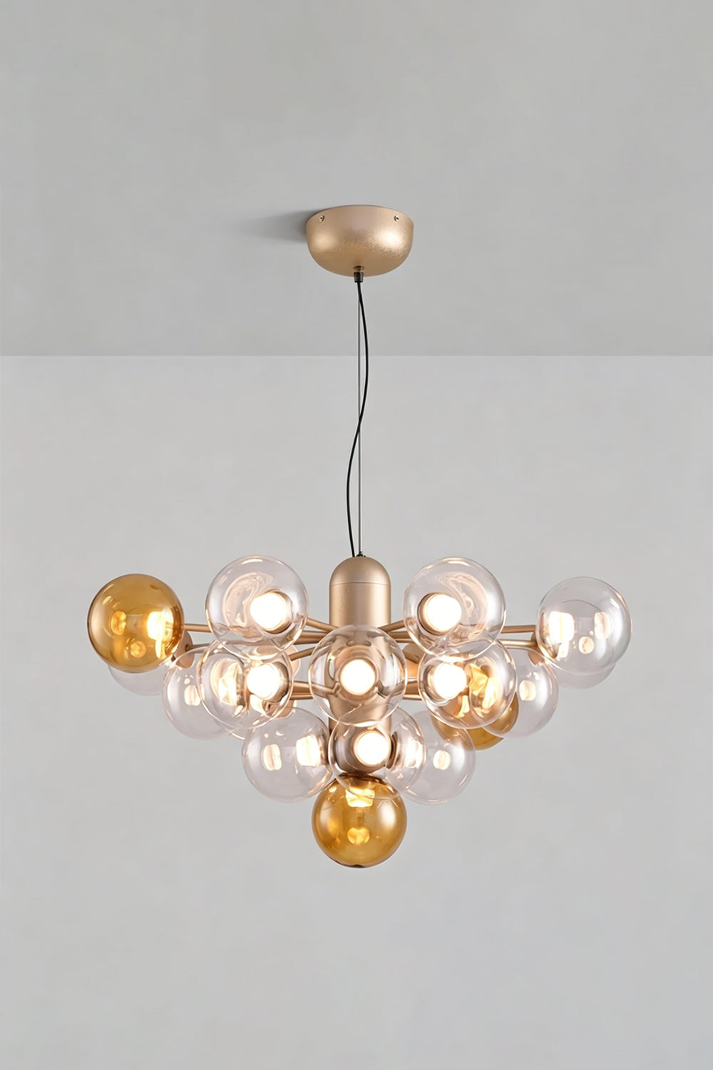 Astraea Prismatic Globe Chandelier | Glass, Metal | Studio view of the amber yellow glass bubble variant fully illuminated against a plain grey backdrop | Samu Lamp