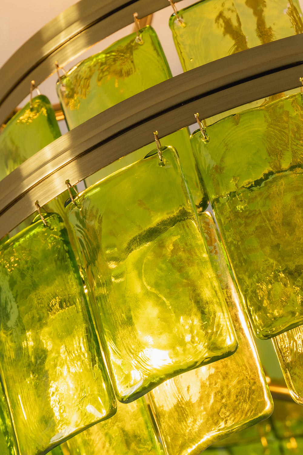 Aura Verdant Tiered Green Glass Ceiling Light | Metal, Glass | Close-up macro view highlighting the fiery golden-green glow through the textured glass panels | Detail shot | Samu Lamp
