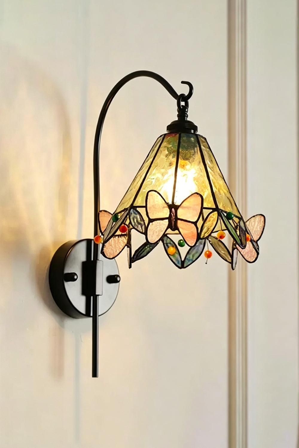 Aura Vine Stained Glass Wall Sconce | Glass, Metal | Frontal angled view of the fully lit lamp radiating soft light against a neutral plain wall | Isolated shot | Samu Lamp