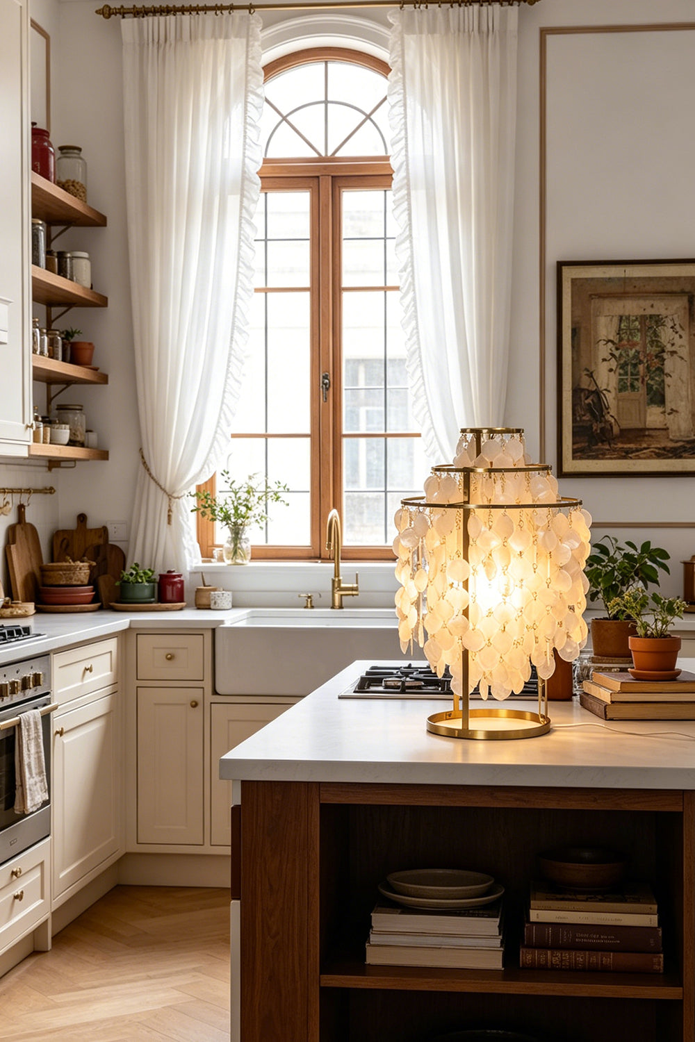 Aurelia Tiered Capiz Table Lamp | Capiz Shell, Metal | Set on a white marble kitchen island counter providing a warm inviting glow next to modern cabinetry | Samu Lamp