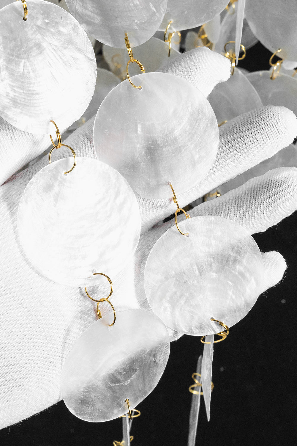 Aurelia Tiered Capiz Table Lamp | Capiz Shell, Metal | Texture close-up view of the delicate shimmering pearlescent capiz shell circles under bright light | Detail shot | Samu Lamp