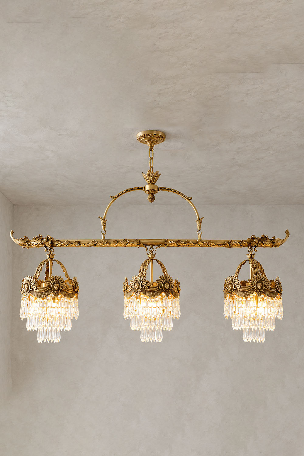 Aurelien Crystal Crown Brass Island Chandelier | Cut Crystal and Brass | 3-light island chandelier variant illuminated on a plain wall background | Samu Lamp