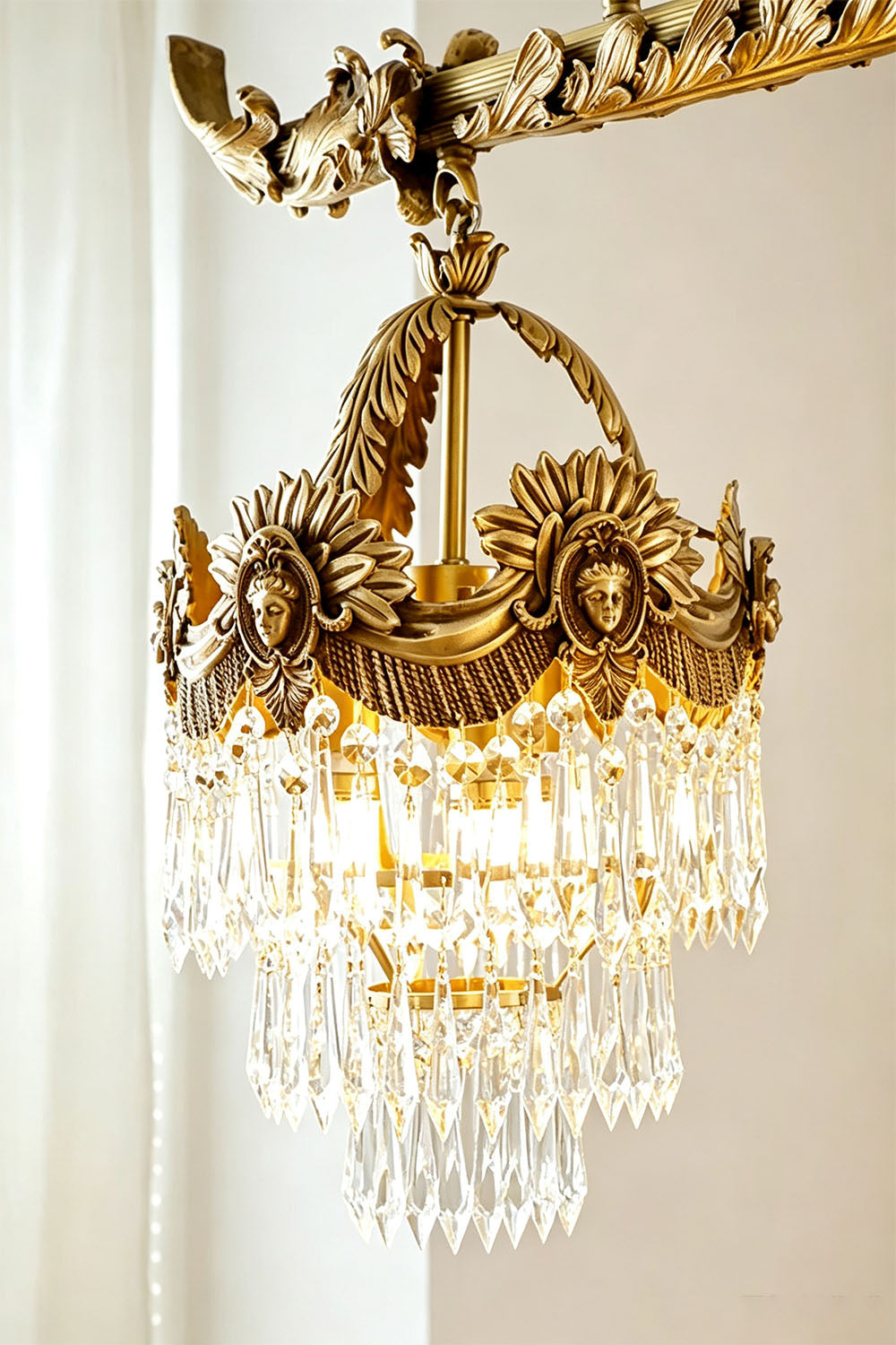 Aurelien Crystal Crown Brass Island Chandelier | Cut Crystal and Brass | Close-up view of an illuminated crystal crown basket and brass frame | Samu Lamp