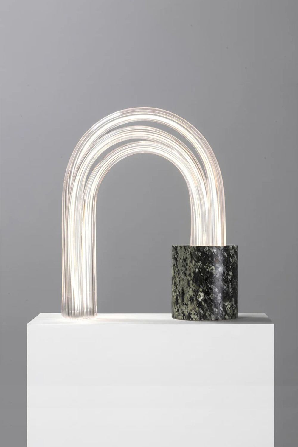Aurelius Ribbed Marble Table Lamp showcasing a ribbed marble base and elegant glass shade, providing warm ambient lighting.