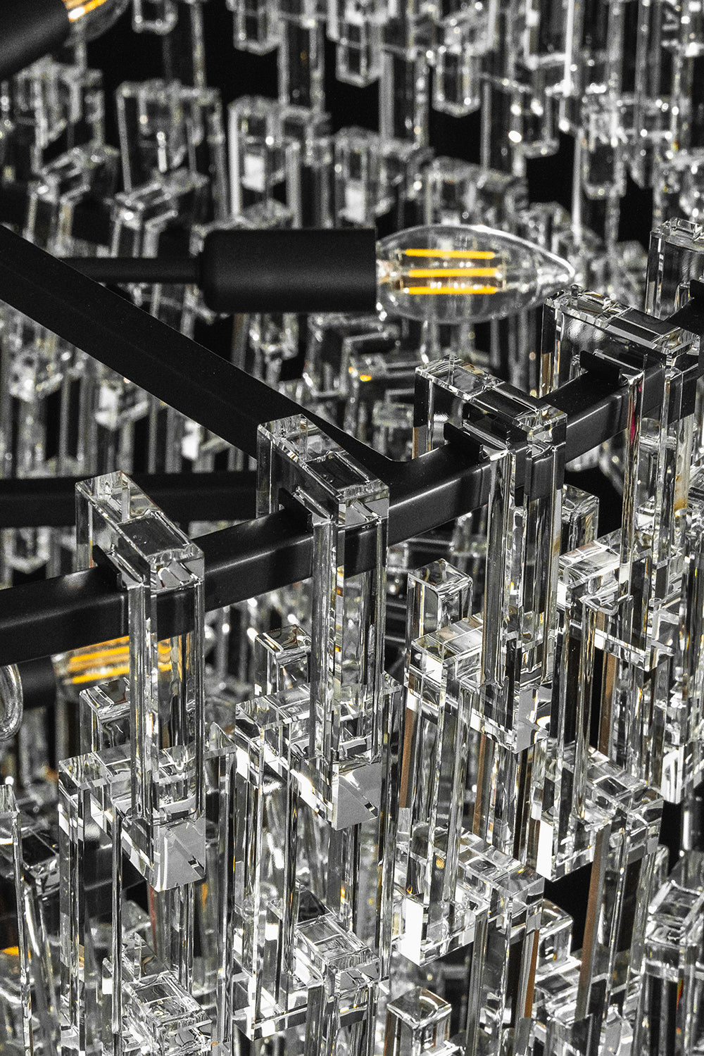 Aven Tiered Glass Prism Chandelier | Glass, Metal | Macro close-up focus on the black metal multi-tier structural frame and internal light bulb sockets | Detail shot | Samu Lamp