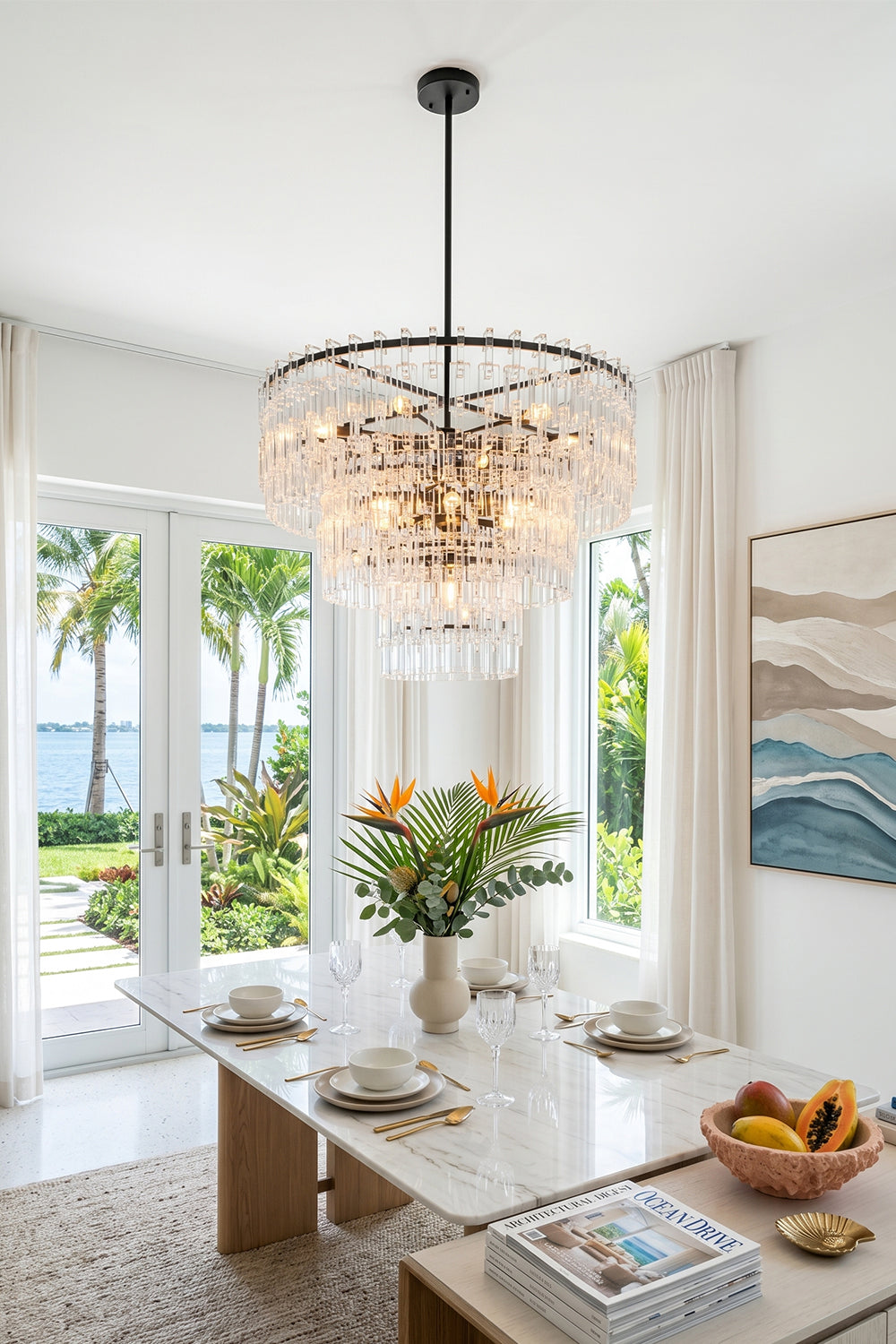 Aven Tiered Glass Prism Chandelier | Glass, Metal | Providing elegant ambient lighting over a contemporary marble dining setup with open sliding doors to a beach view | Samu Lamp