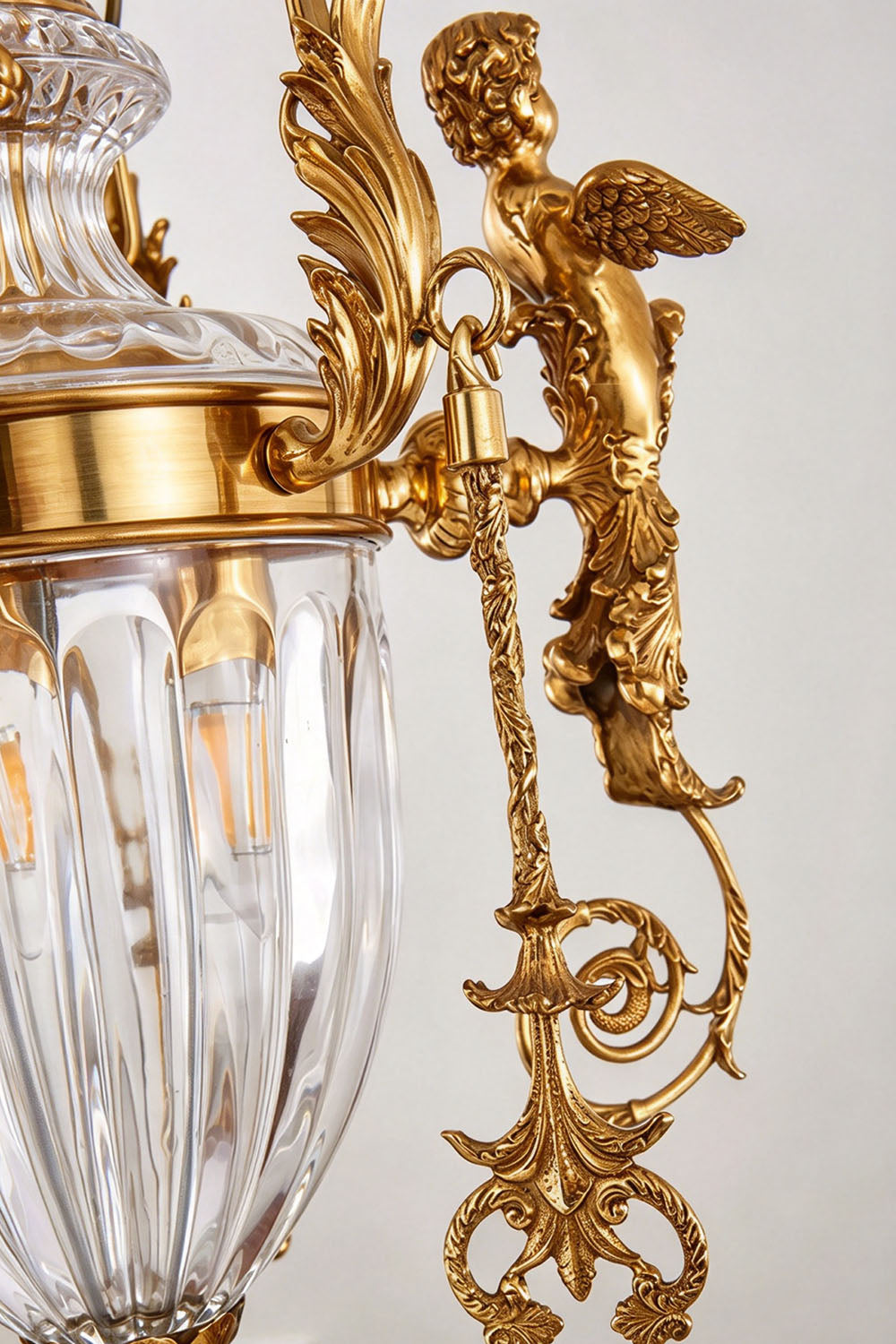 Aveyron Brass Urn Candle Chandelier | Solid Brass and Glass | Detail shot highlighting the carved brass cherub angel sculpture on the arm | Samu Lamp