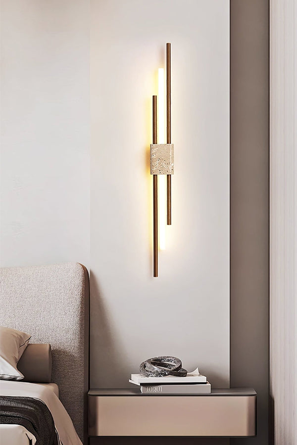 Axis Terra linear wall sconce in a bedroom | Travertine, Metal, Glass | Positioned above a sleek nightstand | Samu Lamp