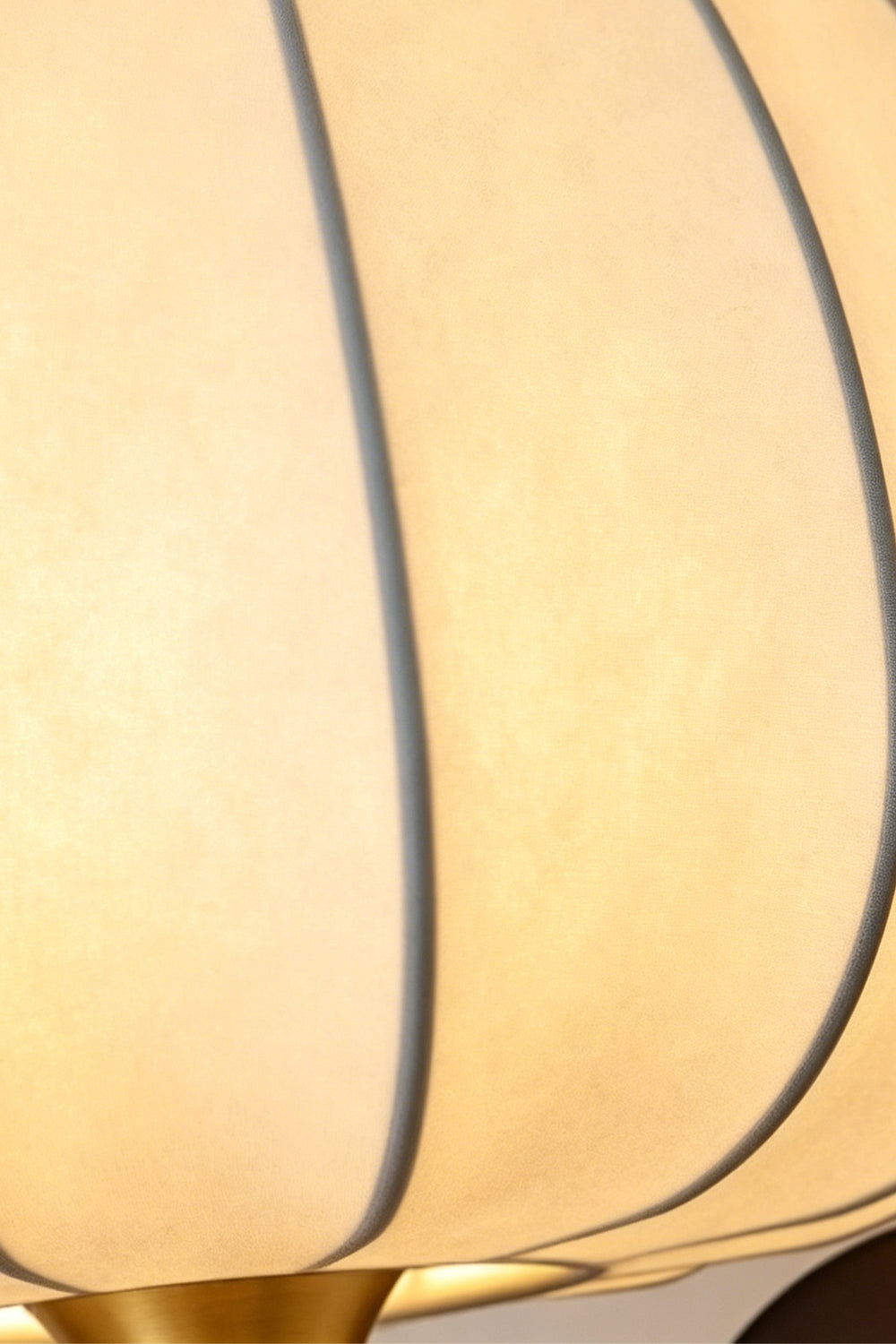 Baird Mid Century Pumpkin Wall Lamp | Metal, Fabric, Wood | Macro focus on the translucent ribbed fabric lampshade with a warm inner glow | Detail shot | Samu Lamp